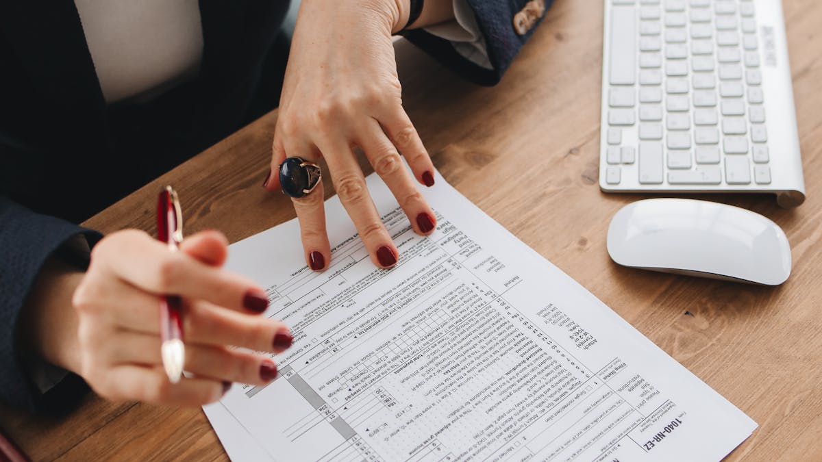 Tax professional reviewing federal tax return documents at a desk