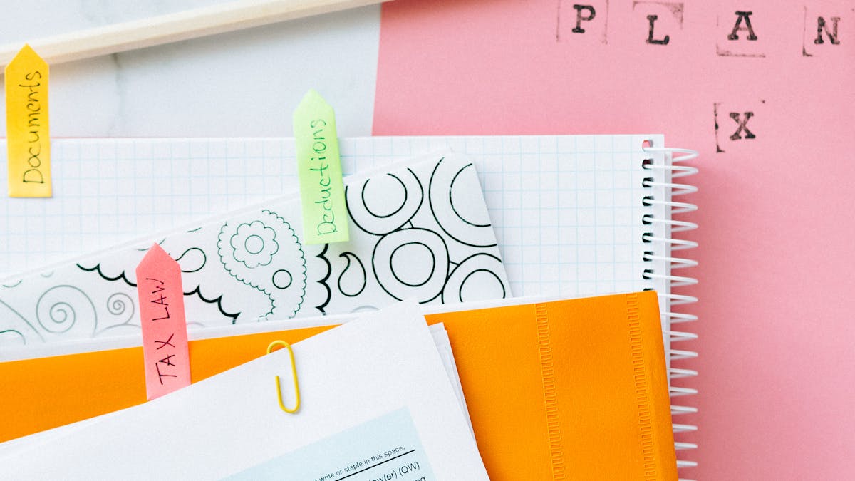 Federal tax forms, notebook, and stationery laid out for quarterly tax planning