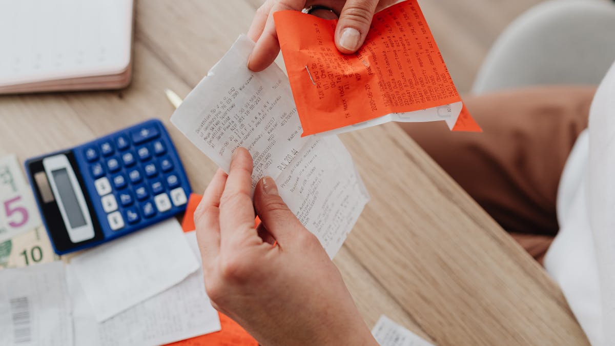 Overhead view of receipts, calculator, and notes used to tally tax deductions